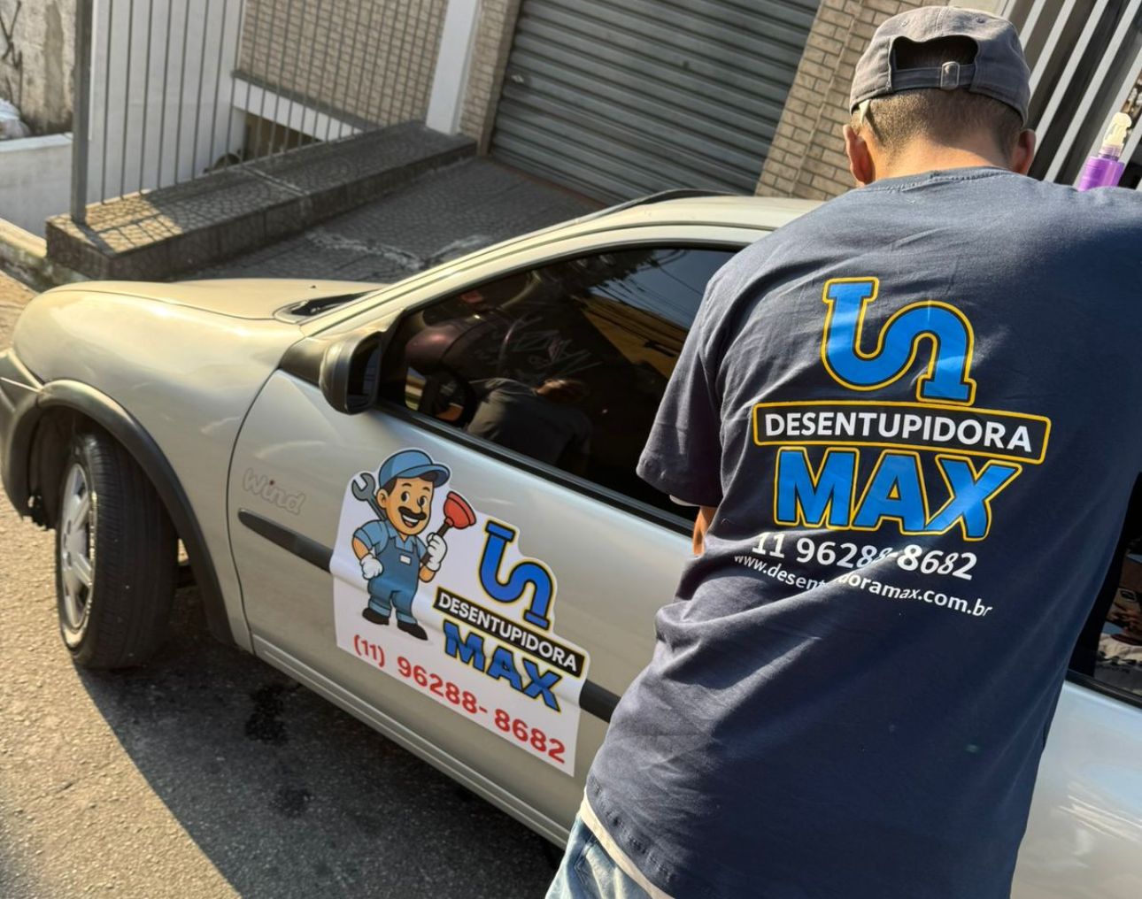 Profissional de desentupimento realizando serviço com equipamento especializado